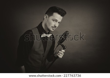 Portrait of a men holding a microphone looking weird at the camera