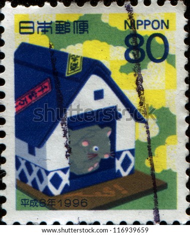 JAPAN - CIRCA 1996: A New Year\'s Greetings stamp printed in Japan shows Satsuma papier-mache rat in rice store, circa 1996