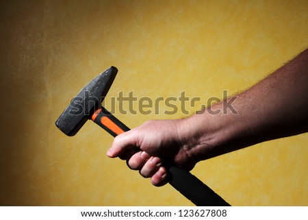 men\'s hand holding a hammer