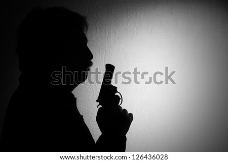 shiluette of man with a revolver, black white