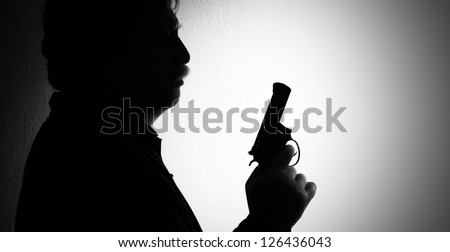 shiluette of man with a revolver, black white