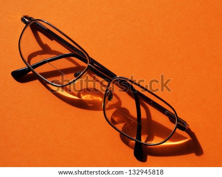 male wire-rim glasses isolated on an orange background