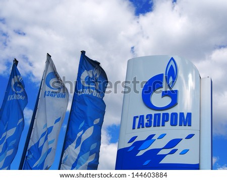 Donetsk - July 3, 2013: Gazprom Logo And Flags Against Blue Sky Of July 3, 2013,Donetsk, Rostov Region, Russia. Open Joint Stock Company Gazprom Is The Largest Extractor Of Natural Gas In The World.