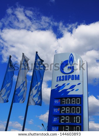 DONETSK - JULY 3, 2013: Gazprom logo and flags against blue sky of July 3, 2013,Donetsk, Rostov Region, Russia. Open Joint Stock Company Gazprom is the largest extractor of natural gas in the world.