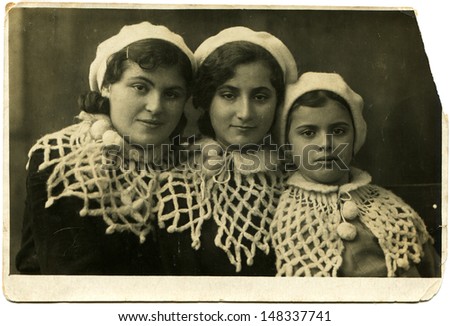 USSR - CIRCA November 19, 1941: Vintage photo shows Three girl-friends in white beret and knitted Pelerin, November 19, 1941