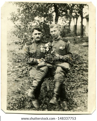 GERMANY - CIRCA Summer, 1945: Vintage photo shows Two soldiers posing with flowers in their hands after getting the news of the demobilization, Germany, Summer 1945