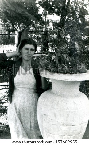 VOROSHILOVGRAD, UKRAINE - CIRCA 1957: young woman in the garden near the flower pot in the form of vases, Voroshilovgrad, now Lugansk, Ukraine, USSR, 1957