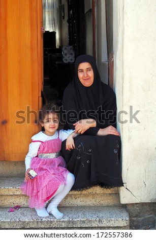 PRINCES ISLANDS, TURKEY - APRIL 23, 2013: woman in hijab with little girl sitting on the steps of her home, Buyukada
