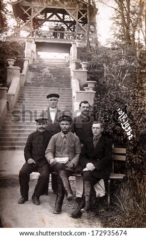 USSR, RUSSIA, CAUCASUS, ESSENTUKI, - July 7, 1936: An antique photo shows five men on the bench in the park of SPA
