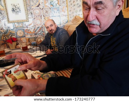 UKRAINE, LUGANSK - JANUARI 26, 2014: Club members share news Beer lovers club meets monthly to exchange symbols in various pubs town. Men bring to meetings beer mats, labels and stoppers.