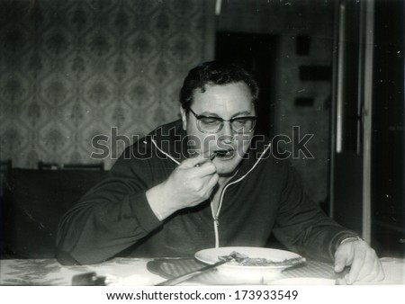 GERMANY, BERLIN -  1960s: An antique photo shows man eating soup