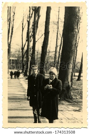GERMANY, GORLITZ -  CIRCA March 14, 1954: An antique photo shows woman and a young man with glasses in the park