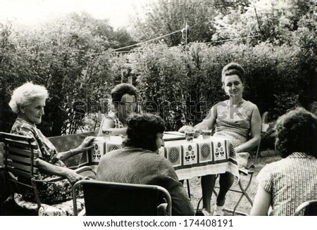 GERMANY, BERLIN -  CIRCA 1955: An antique photo shows five women sits near the table in the garden,  1955, Berlin
