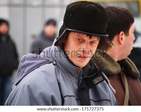 UKRAINE, LUGANS - FEBRUARY 9, 2013: Man is a rally participant. Organized under flags of Russia and Ukrainian SSR defunct rally in support of SWAT Berkut gathered  in the center about 30-40 people.