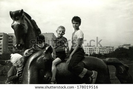 ROSTOV - 1987: two boys seating on the back of horse sculpture, Rostov-on-Don, Russia, 1987. Name of boys are Victor and Vadim, 6 and 7 years old.