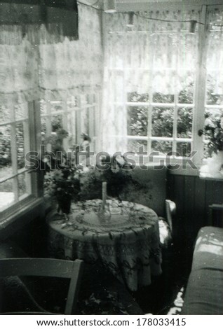 GERMANY, LEIPZIG -  CIRCA 1939: An antique photo shows table covered with a tablecloth, candlestick and two bouquets standing on the veranda, Leipzig