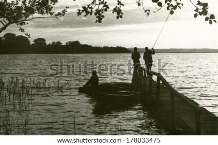 GERMANY -  1960s: An antique photo shows three men fishing on the lake