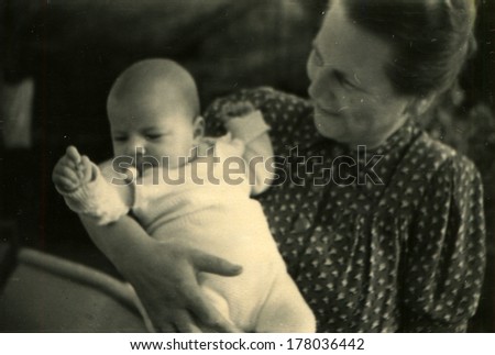 GERMANY, WAREN - MURITZ, MECKLENBURG-WESTERN POMERANIA -  CIRCA 1953: An antique photo shows woman with baby