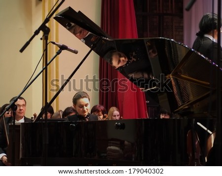 UKRAINE, LUGANSK - FEBRUARY 27, 2014: Lugansk Philharmonic Orchestra performed the Concerto No1 for piano and orchestra by Camille Saint-Saens. Conductor is Catherine Osadchaya, soloist - Irina Burgan.