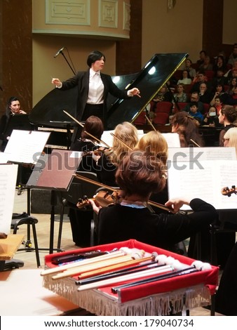 UKRAINE, LUGANSK - FEBRUARY 27 2014:Lugansk Philharmonic Orchestra performed the Concerto No1 for piano and orchestra by Camille Saint-Saens. Conductor is Catherine Osadchaya, soloist - Irina Burgan.