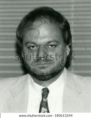 GERMANY - CIRCA 1970s: An antique photo of middle-aged man with a beard in a light business suit on background blinds