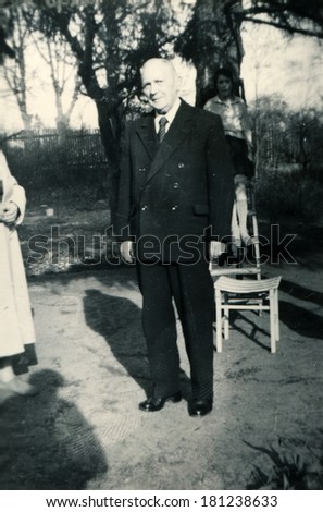 GERMANY - April 11, 1961: An antique photo of elderly man in formal suit posing in the garden in honor of his 79th birthday