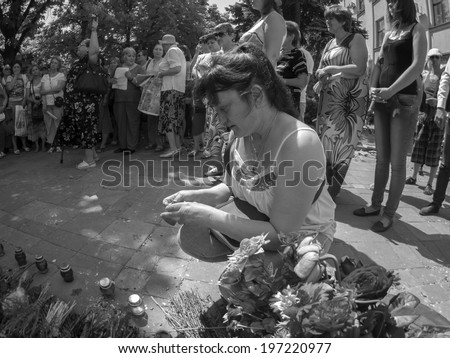 LUHANSK, UKRAINE - June 7, 2014: A woman lights the memory candle during a rally against the inauguration of Ukraine\'s new president in Luhansk