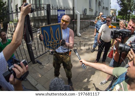 LUHANSK, UKRAINE - June 9, 2014:  Pro-Russian militia demonstrates reporters Ukrainian coat of arms removed from the gate. Pro-Russian militias  removed from the gate State Emblem of Ukraine.