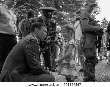 LUHANSK, UKRAINE - June 29, 2014: The  the self-proclaimed parliament of Novorossia speaker Oleg Tsarev talking to little girl, watching them elderly man in uniform with numerous awards on the jacket