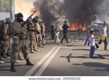 KYIV, UKRAINE - Aug 7, 2014: Woman begs police not to demolish the barricades and tents. Activists and police have clashed in Ukrainian capitals center after communal workers tried to dismantle camp.