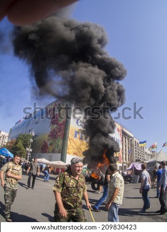 KYIV, UKRAINE - Aug 7, 2014: Activists throw tires in the fire. -- Activists and police have clashed in the Ukrainian capitals center after communal workers tried to dismantle the camp.