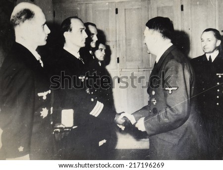 GERMANY - CIRCA 1940s: Adolf Hitler rewards group of naval officers, far right, Grand Admiral Karl Donets Commander Submarine Force