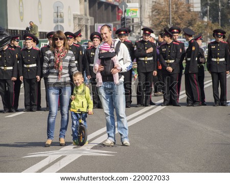 UKRAINE, KYIV - September 27, 2014: Young family posing on a background of military school cadets.