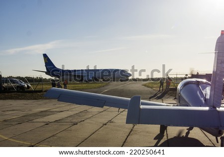 UKRAINE, KYIV - September 28, 2014: Light aircraft waits for permission to take off during the landing of scheduled passenger aircraft.