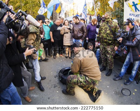 KIEV , UKRAINE - October 10, 2014: Avtomaydan Activist tries to set fire to a tire before the passage of the Presidential Administration