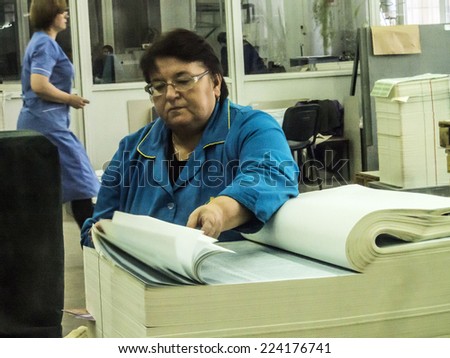 KIEV, UKRAINE - October 17, 2014: Workers control quality of ballots for early parliamentary elections in the pressroom of the State printing plant 