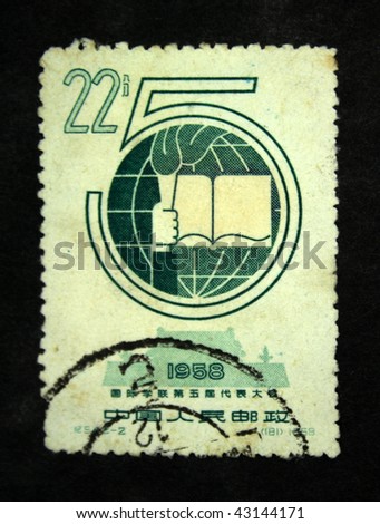 CHINA - CIRCA 1958: A stamp printed in China shows nomber 5, earth, open book and pen on the background of Forgibben town, circa 1958