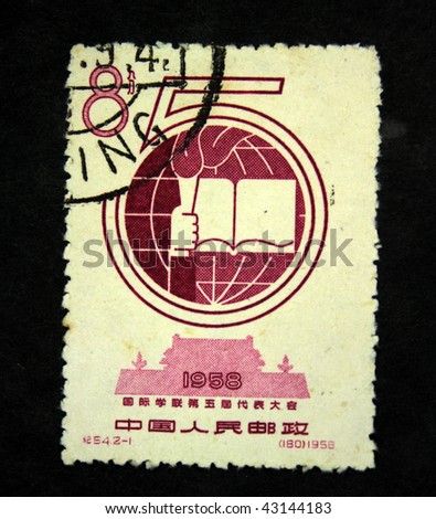 CHINA - CIRCA 1958: A stamp printed in China shows nomber 5, earth, open book and pen on the background of Forgibben town, circa 1958