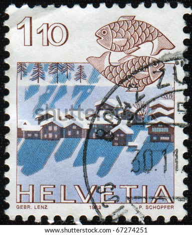 SWITZERLAND - CIRCA 1983: A stamp printed Switzerland, officially Confideratio Helvetica, shows Zodiac sign Pisces on the background image of winter village, circa 1983.