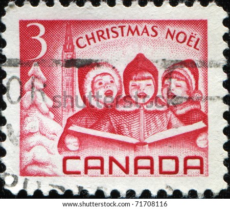CANADA - CIRCA 1967: A stamp printed in Canada  shows three singing child with a book in their hands against the backdrop of the Christmas tree and the parliament, circa 1967