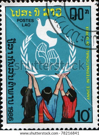 LAOS - CIRCA 1986 : A stamp printed in Laos shows group of children released a white dove, is devoted to the International Year of Peace, circa 1986