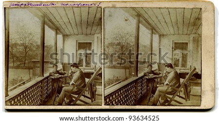 RUSSIA - CIRCA 1913: An antique photo shows stereo, a man with a boy playing checkers on the porch at home, the Russian Empire, 1913 Russian text: quandary
