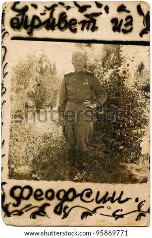 USSR - CIRCA 1940s: Portrait of a Soviet Army soldier who was awarded two medals, Feodosia, Crimea, circa 1940s. Russian text: Hello from Feodosia