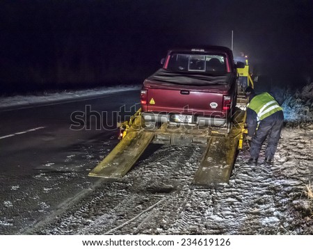 KIEV, UKRAINE - December 2, 2014: Truck Ford Ranger was evacuated after the breakdown on the winter road near Kiev, Ukraine. Due to delays in the repair of the car broke the rear axle shaft.