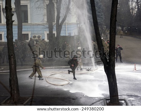 KIEV, UKRAINE - February 2, 2015: Firefighters are trying to bridge the gap hose hose, which made fighter Volunteer Battalion Aydar into the courtyard of the Ministry of Defense of Ukraine in Kiev.