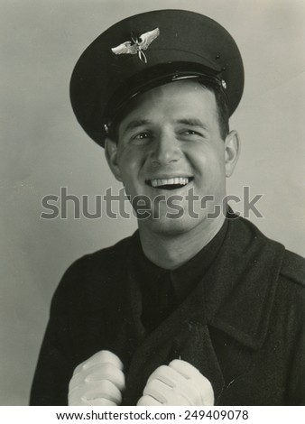 CANADA - CIRCA 1950s: Reproduction of an antique photo shows studio portrait of smling man in pilot cap