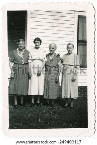 CANADA - CIRCA 1930s: Reproduction of an antique photo shows four women posing against private home