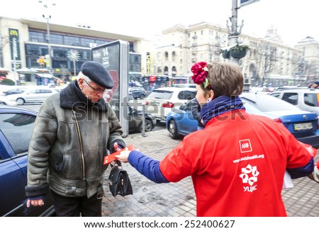 KIEV, UKRAINE - February 13, 2015: Volunteer gives pensioner pack of condoms on the main street of Kiev, Khreschatyk, celebrating the Day of the condom.
