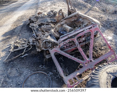 NIKISINO, UKRAINE - Feb 27, 2015: Broken car lying in the street .  - Village Nikishino located 20 km from Debaltseve, Ukrainian military was abandoned three days ago.
