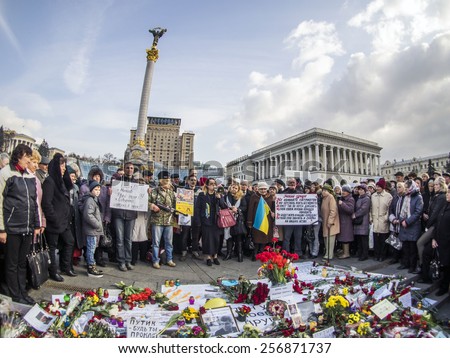 KIEV, UKRAINE - MARCH1, 2015: At a rally in memory of Boris Nemtsov speaks Russian human rights activist Elena Vasileva (with loudspeaker), next to it stands a man wearing a mask of Vladimir Putin.